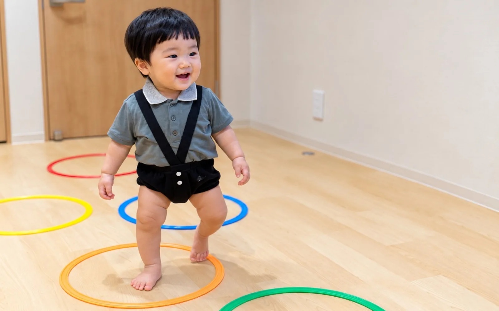 カラフルな輪の中を笑顔で歩くお子さま